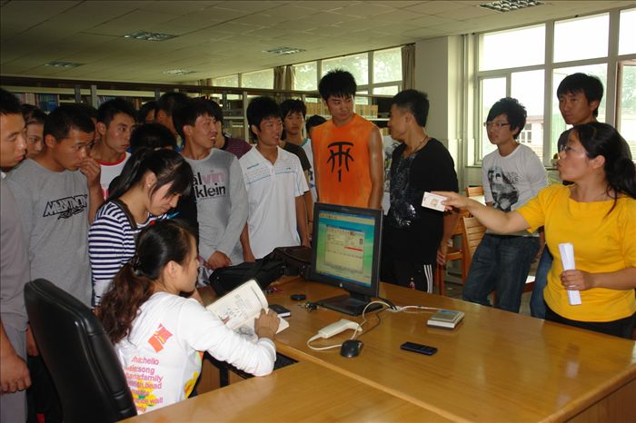 曹老师正在给学生讲解如何借还图书